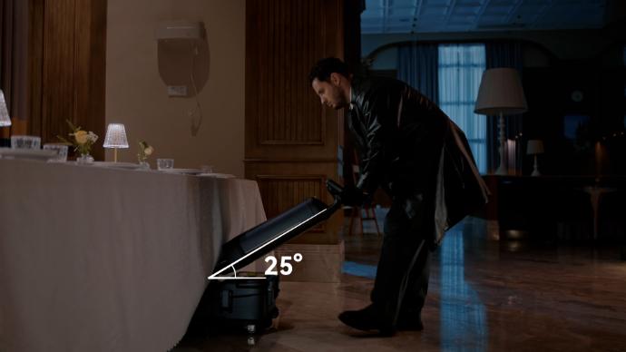 Ein Mann reinigt den Boden unter dem Tisch in einem Restaurant mit dem Reinigungsroboter Pudu SH1.