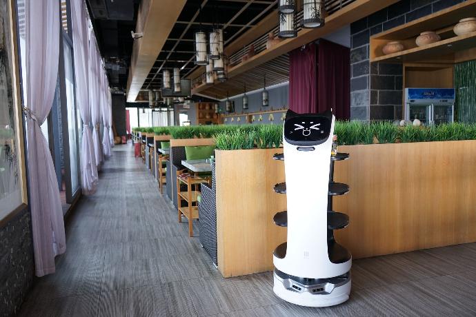 Pudu Robotics BellaBot steht in der Mitte eines Restaurants