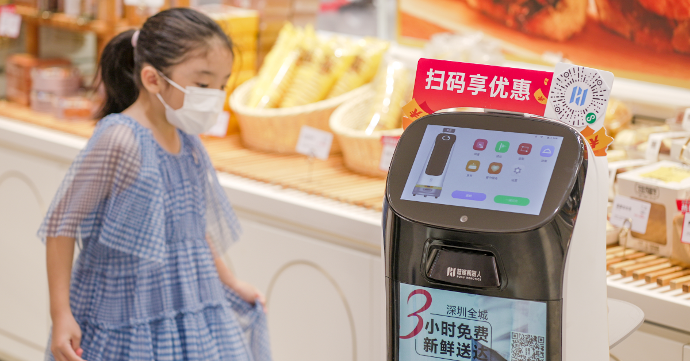 Bild eines Pudu Robotics Marketingroboters namens KettyBot, mit schlankem, hohem Design in Weiß und schwarzem Display, auf dem 'KettyBot' und chinesische Schriftzeichen angezeigt werden.